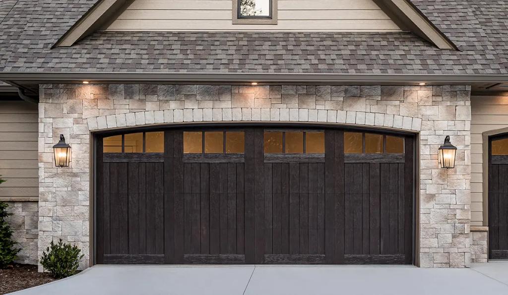 Dark wood carriage house style garage door with stone surround
